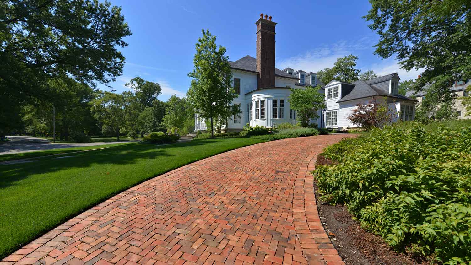 A beautiful upscale house with a brick driveway