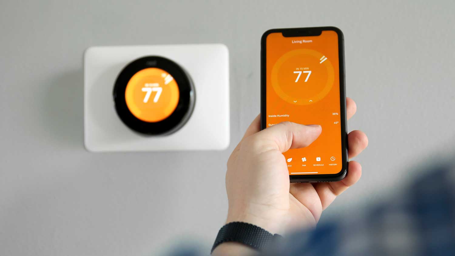 Man using smart thermostat app on his phone