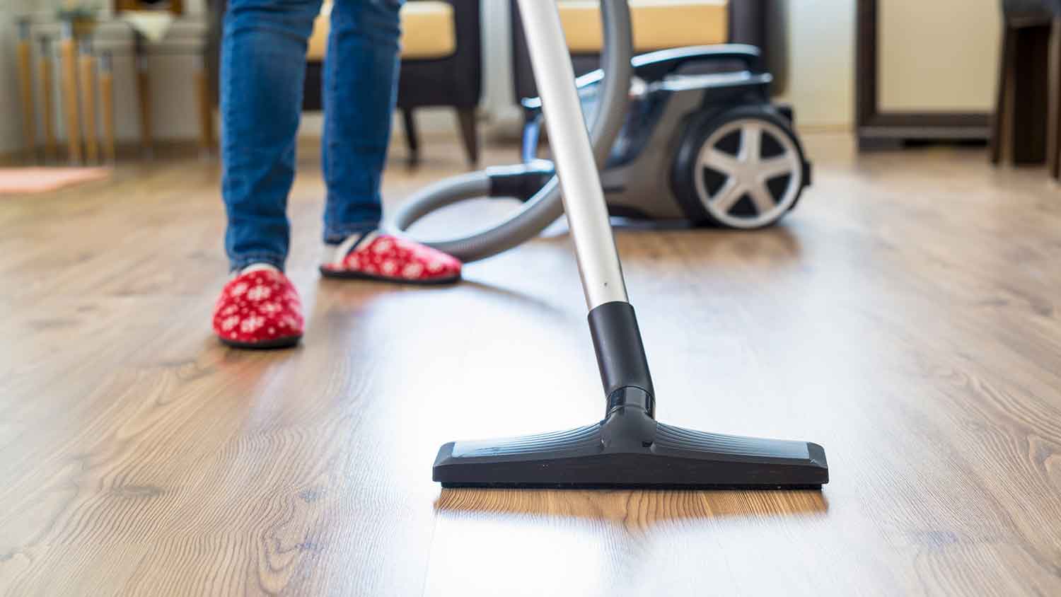 A person vacuuming wood floors