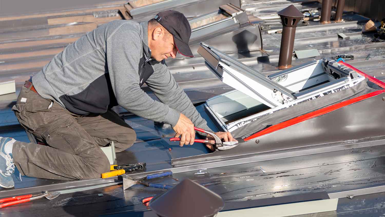Professional installing a vented skylight in the roof of a house