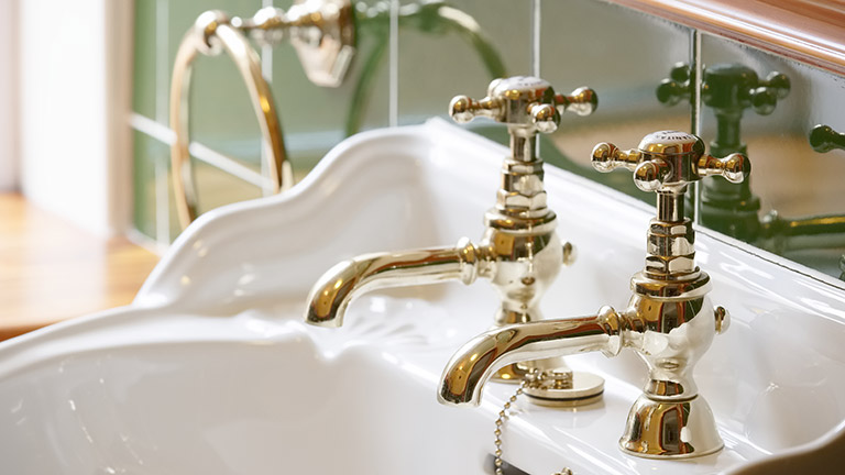 A vintage brass sink in a bathroom