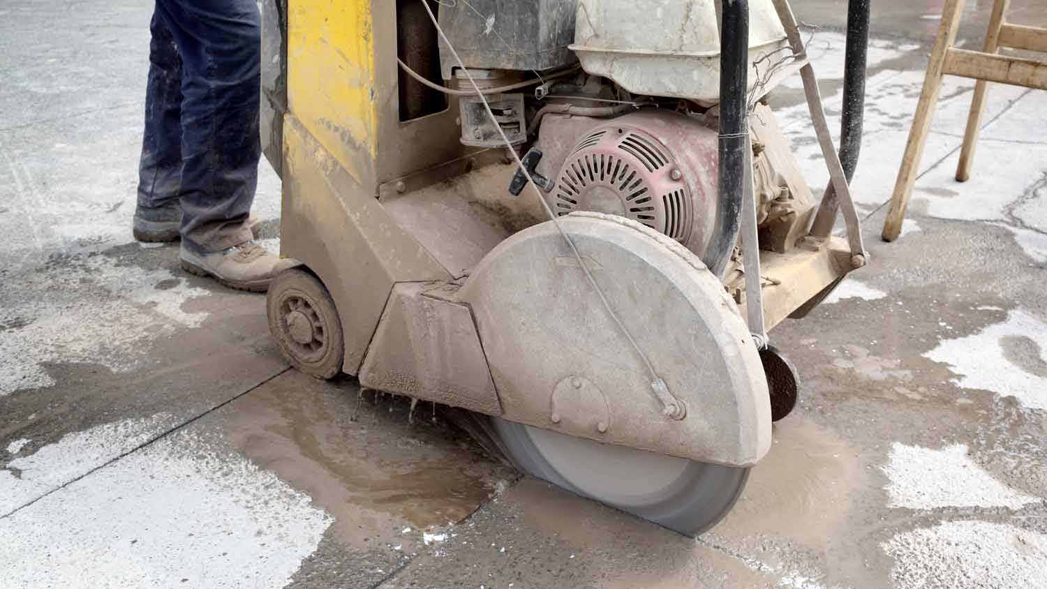 man using a large walk behind concrete saw