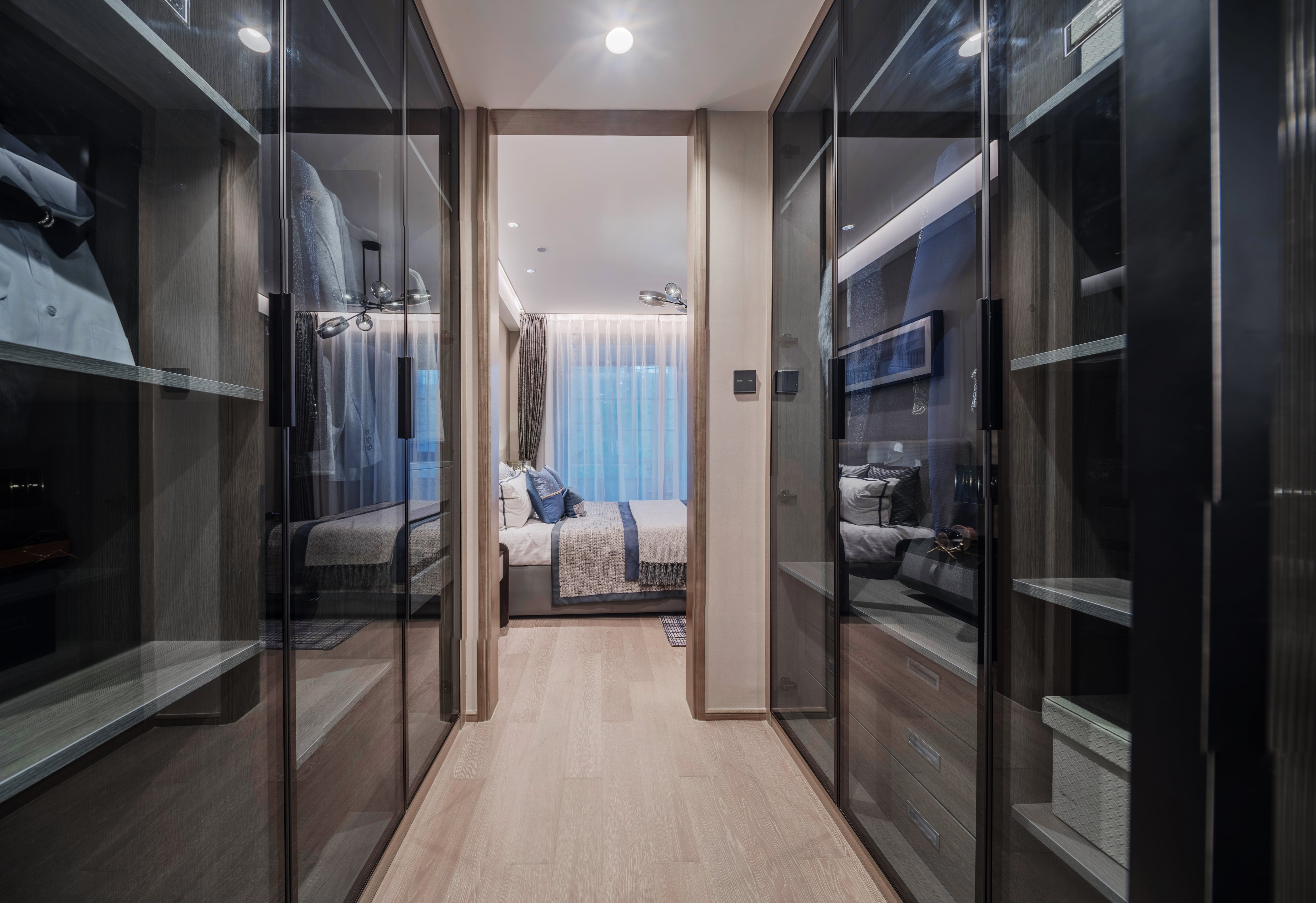 A sleek walk-in closet with all glass display cabinets