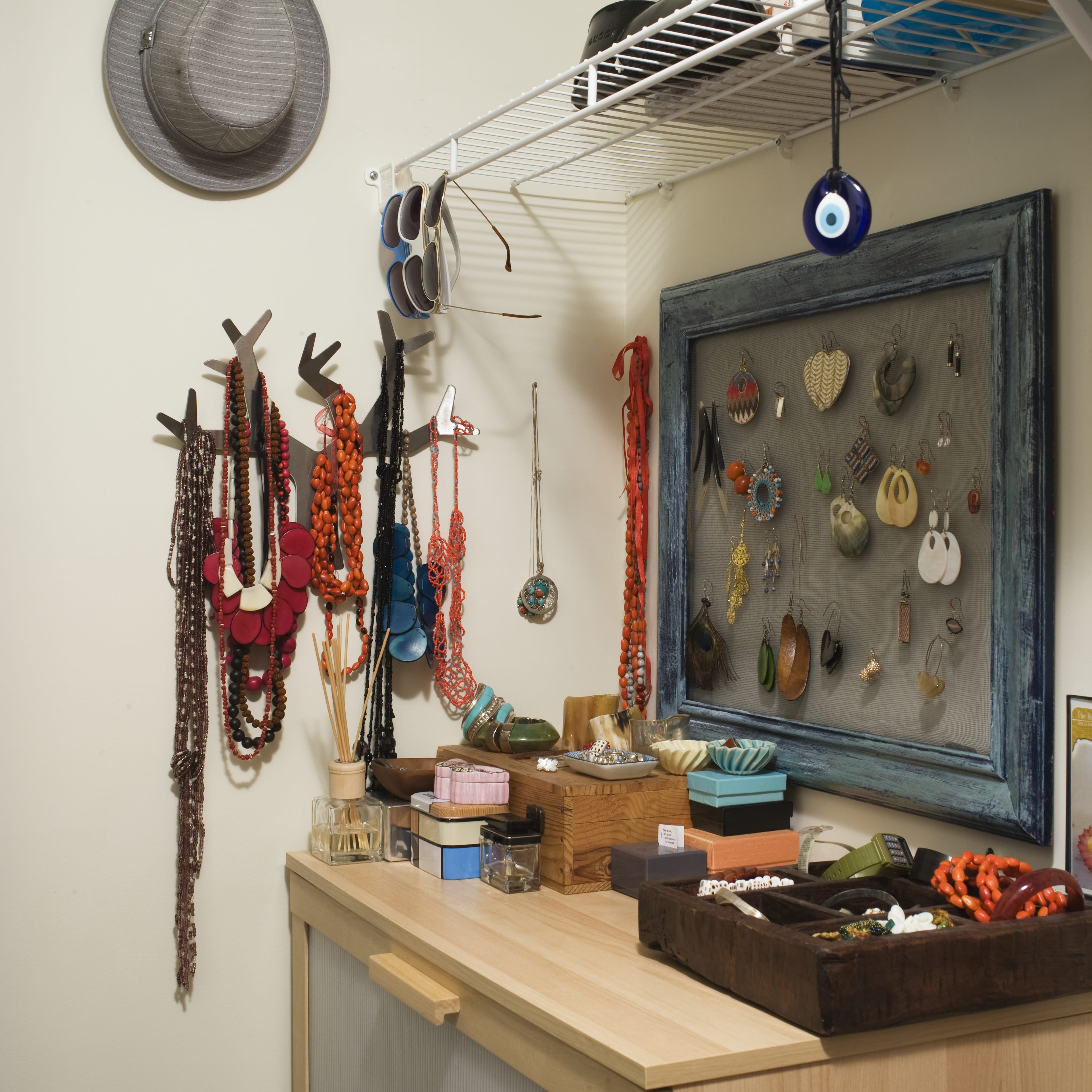 Closeup image of jewelry hanging on a wall next to a desk