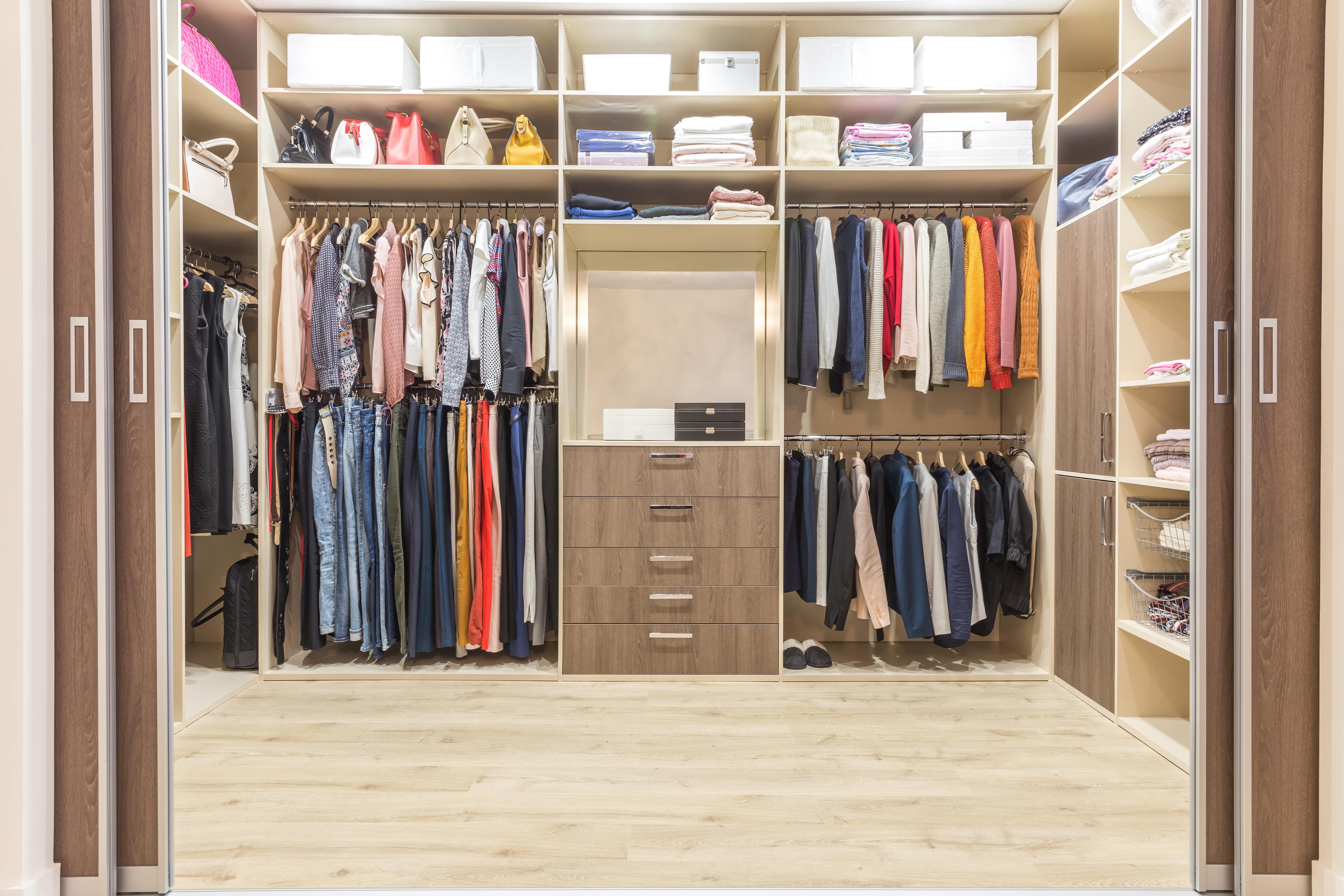 A neatly organized walk-in closet with sliding doors 