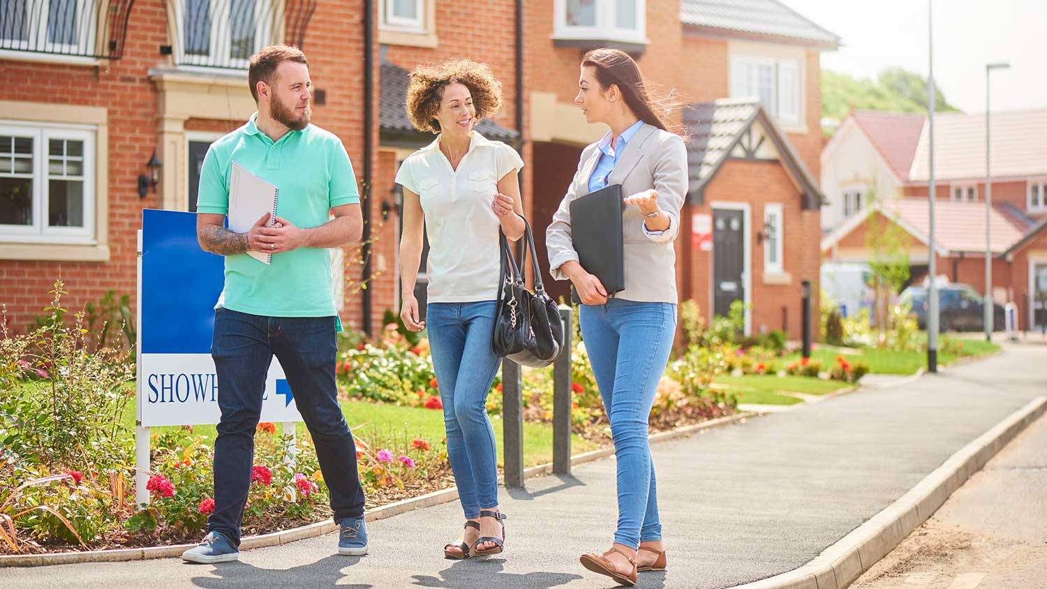 Relator and clients walking outside housing development 