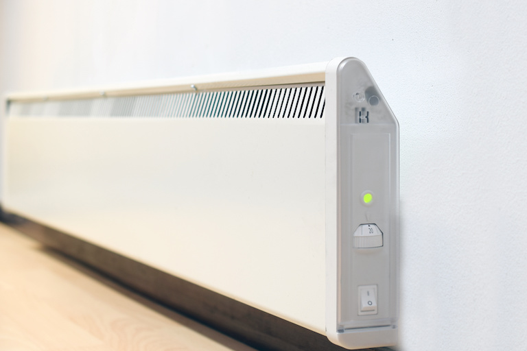 a wall-mounted electric heater in a white room