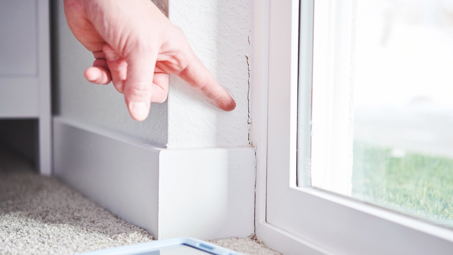 inspector pointing at a crack in the basement wall of a residential property during a home inspection 