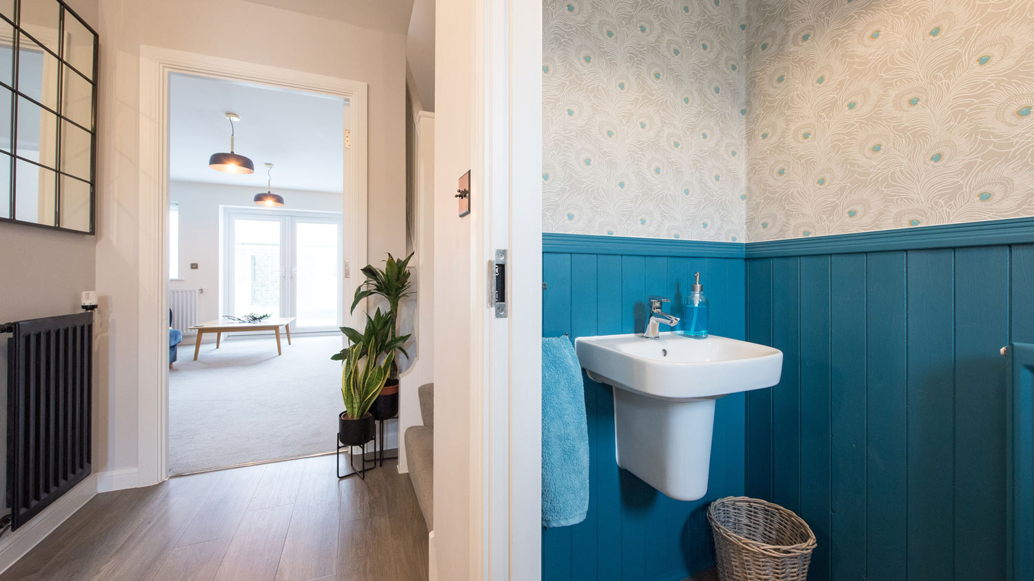 Bathroom with patterned wallpaper above blue wood paneling