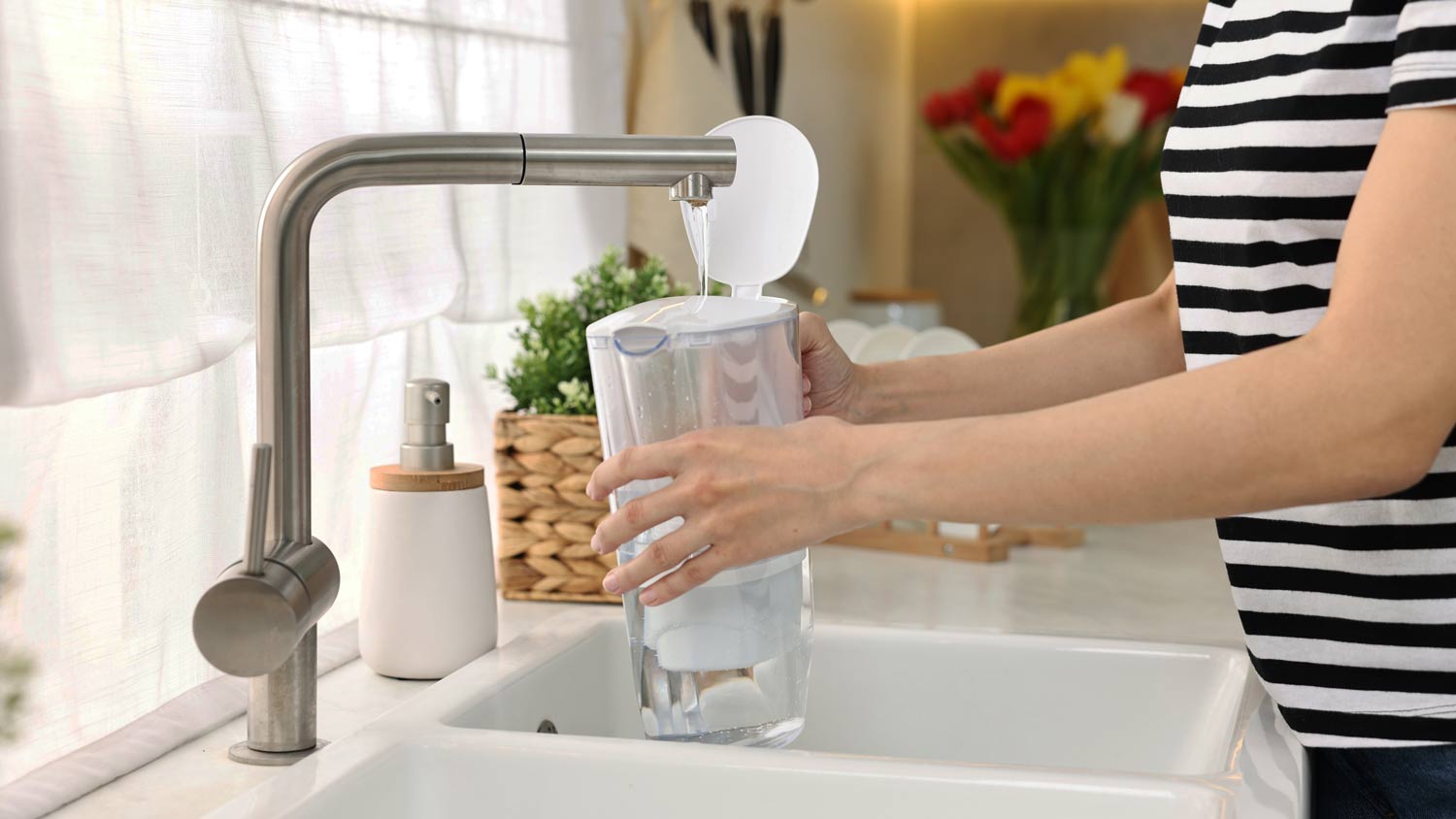 woman pouring water into filter jug