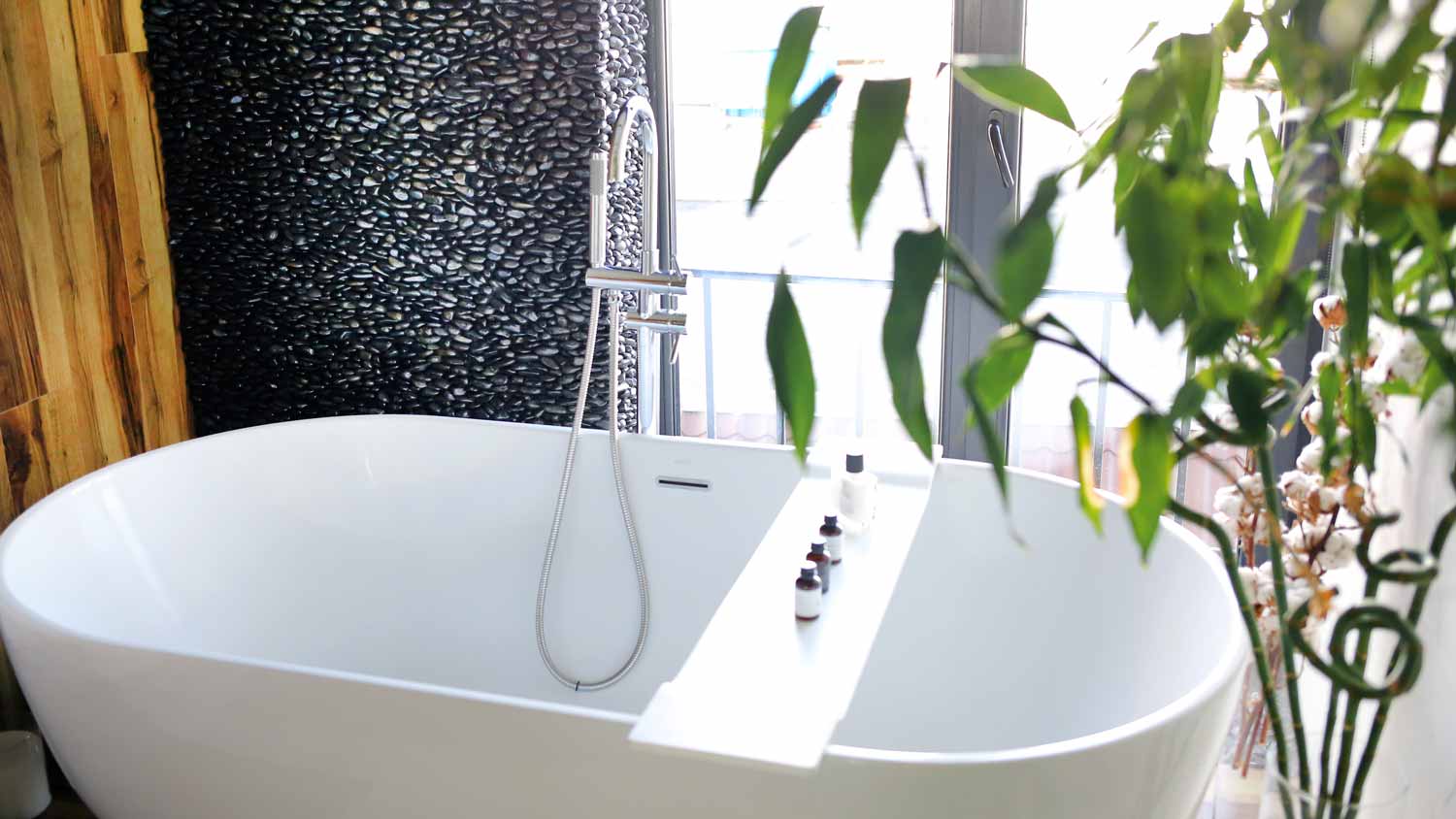 A white acrylic bathtub in a bright bathroom