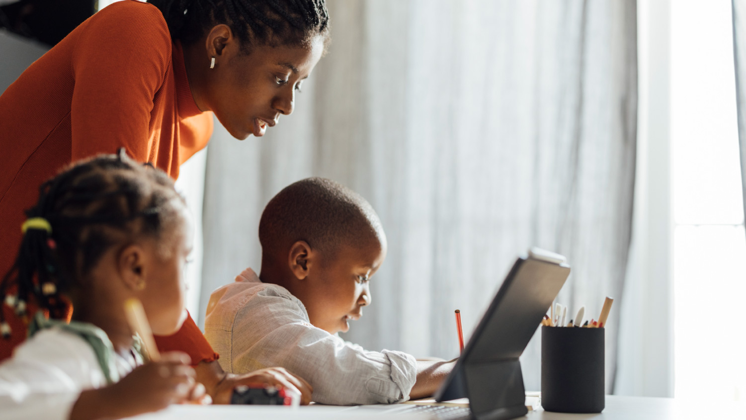 mom and kids learning in a white room
