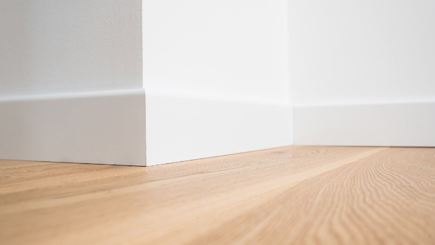 White baseboard and parquet floors