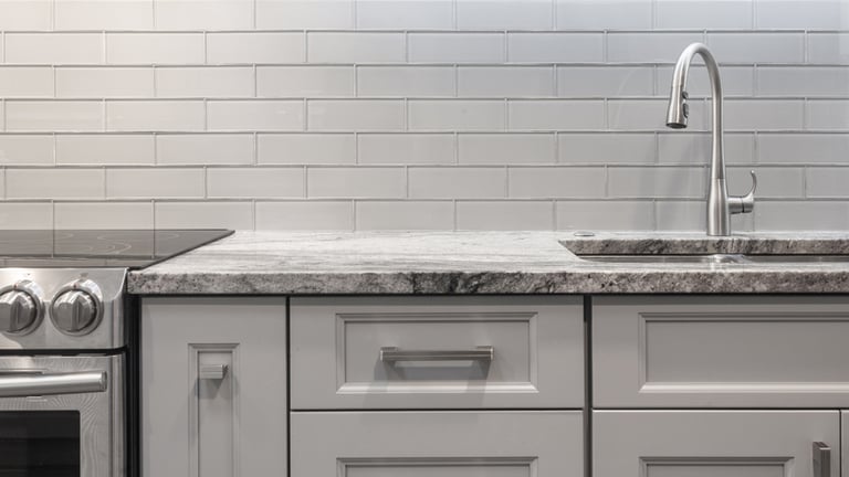 White glass backsplash in white kitchen