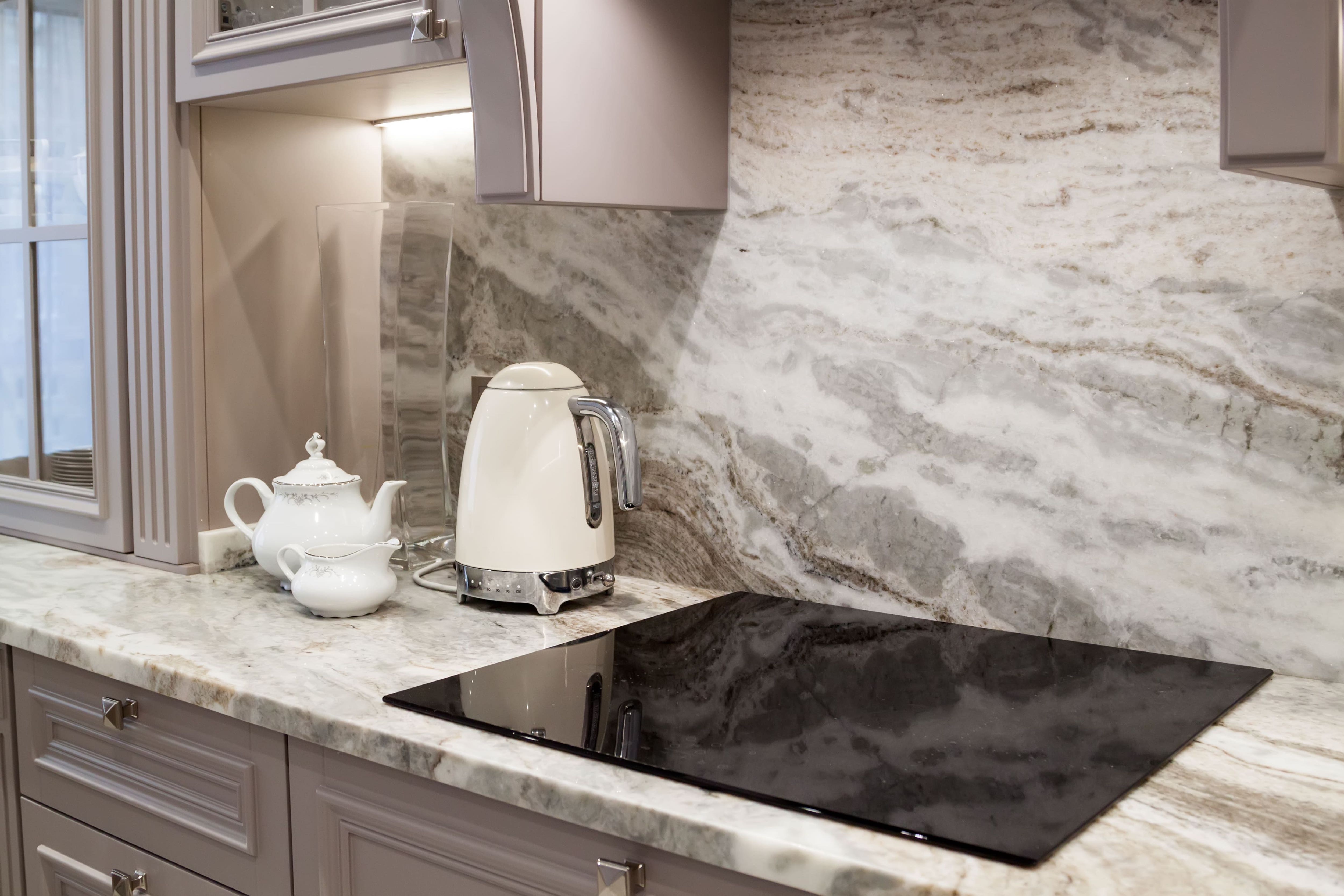 Closeup of white, gray, and taupe quartz countertop with marble-style veins 