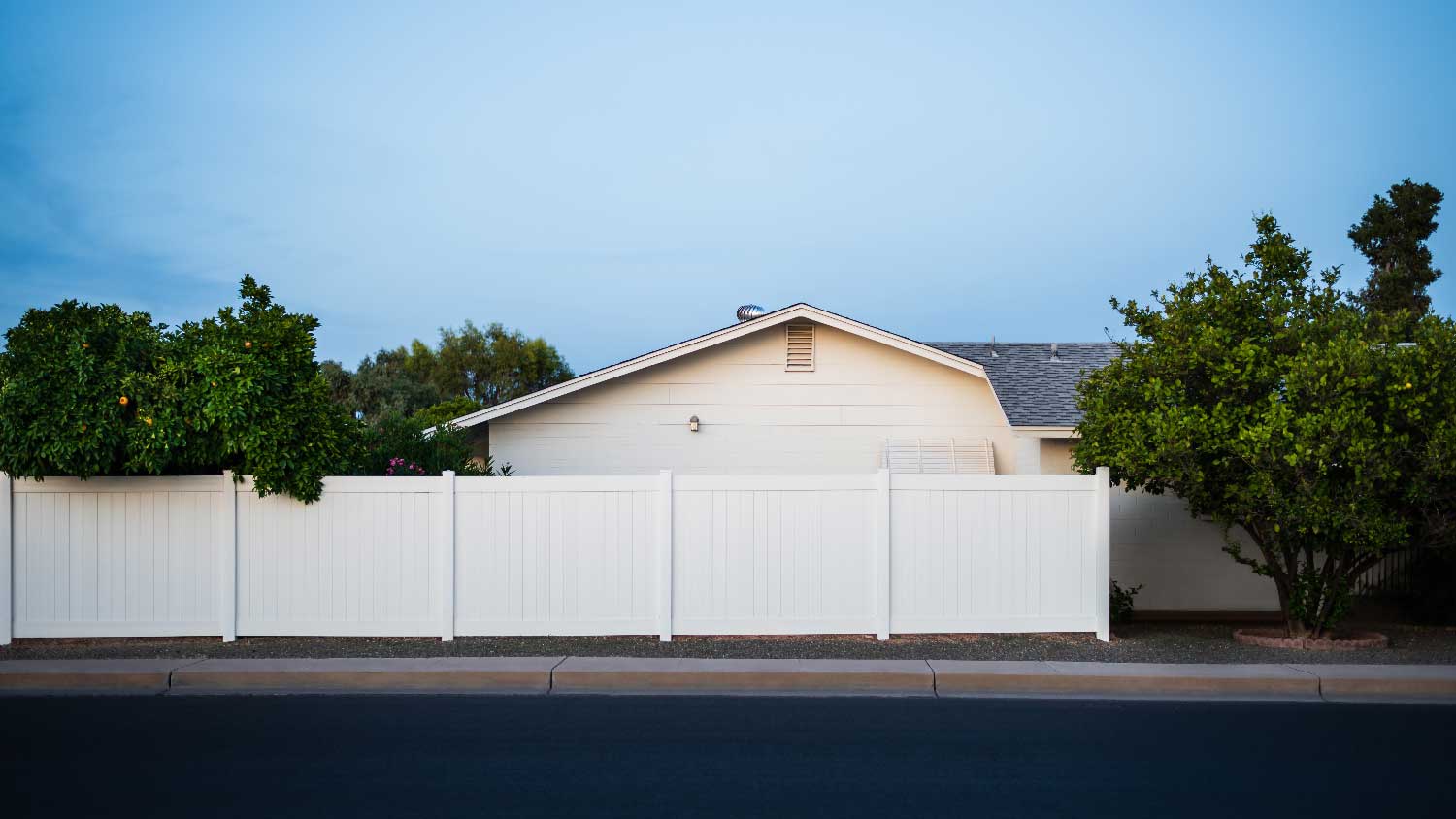 Side view of a house with white privacy fence