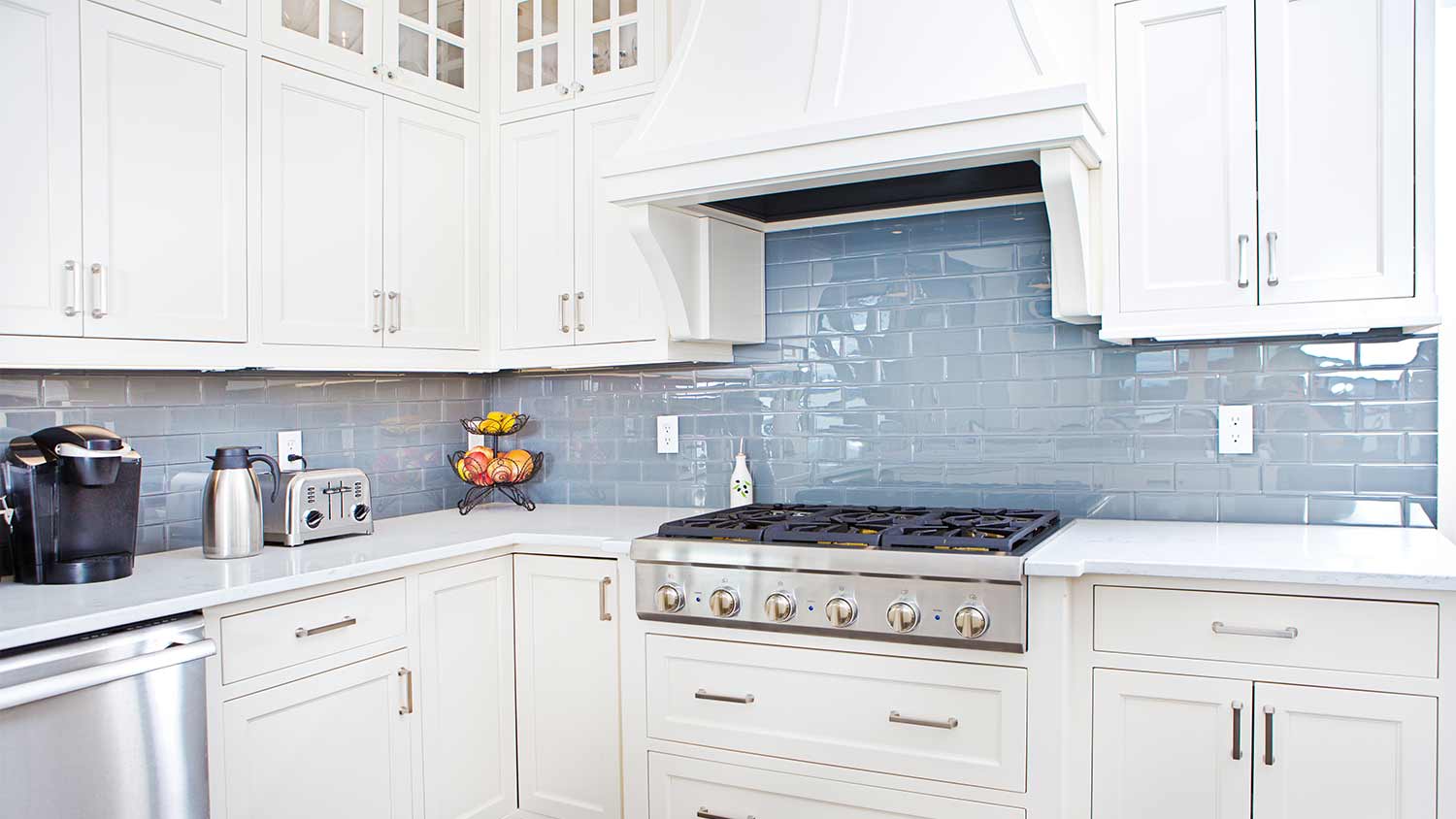 kitchen with white cabinets and blue backsplash
