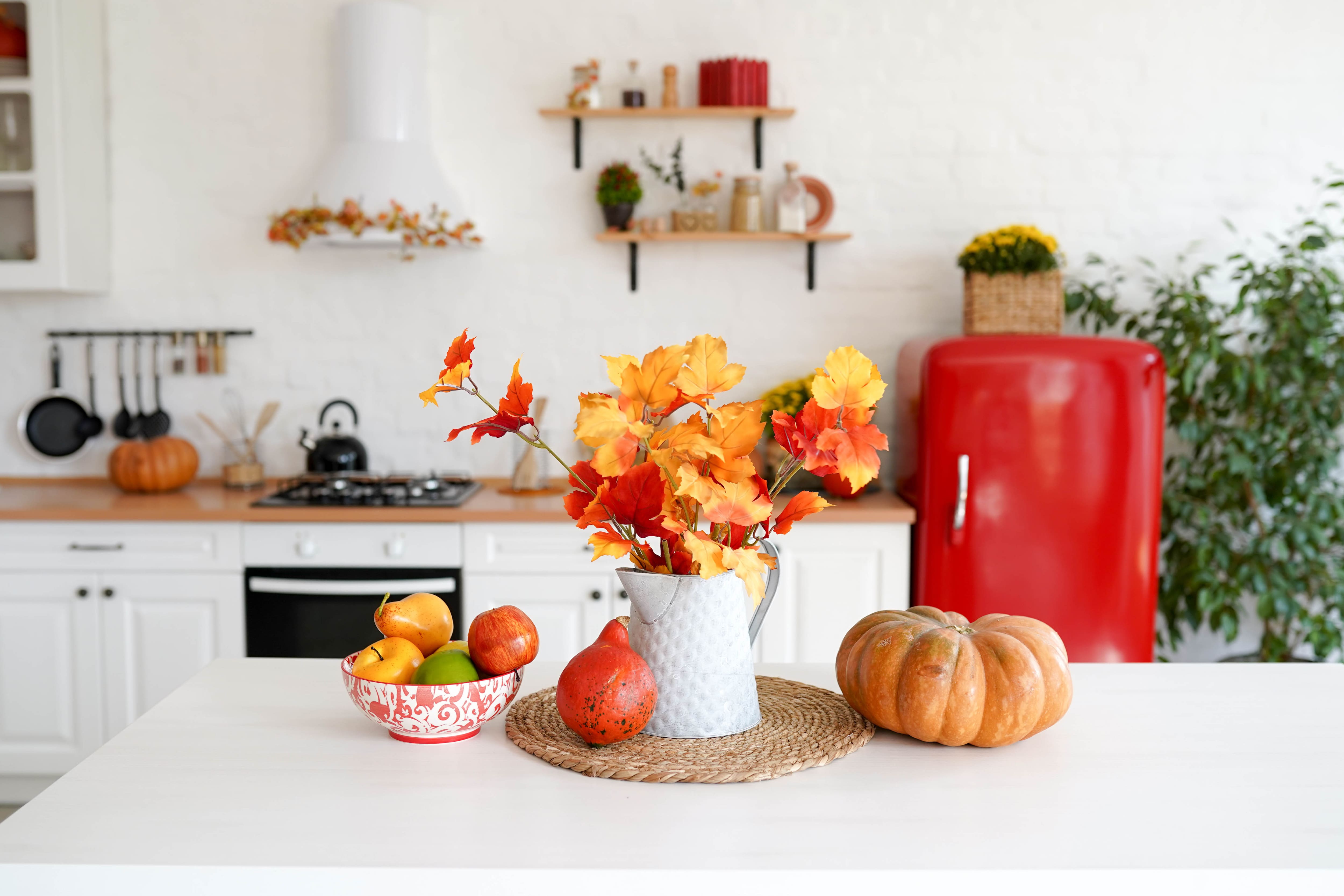 Fall decorations on a table in a white and red kitchen