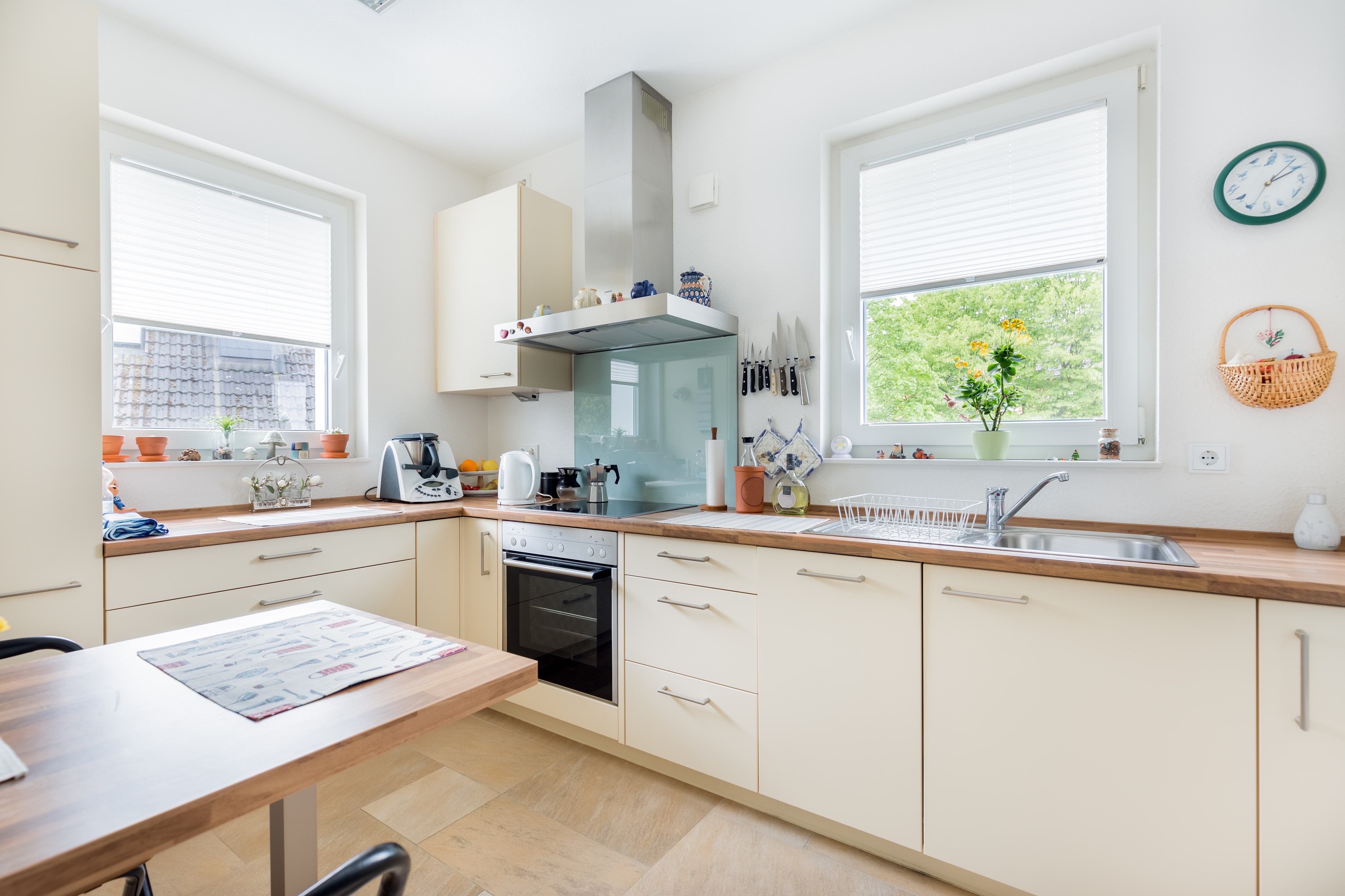 A off-white kitchen with a bright blue backsplash above the stove 