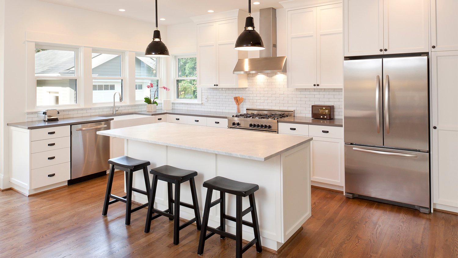 white kitchen with island and bar stools