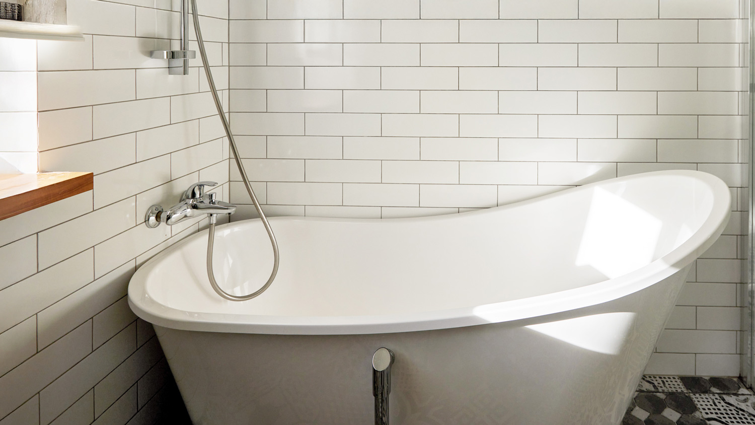 White bathroom with a white tub and a shower