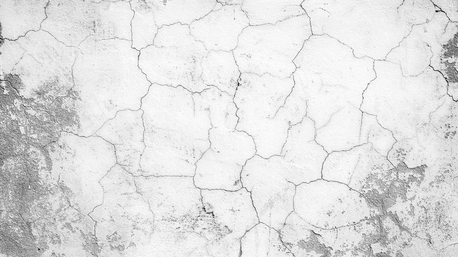 Close-up of a cracked and weathered concrete wall texture in black&white