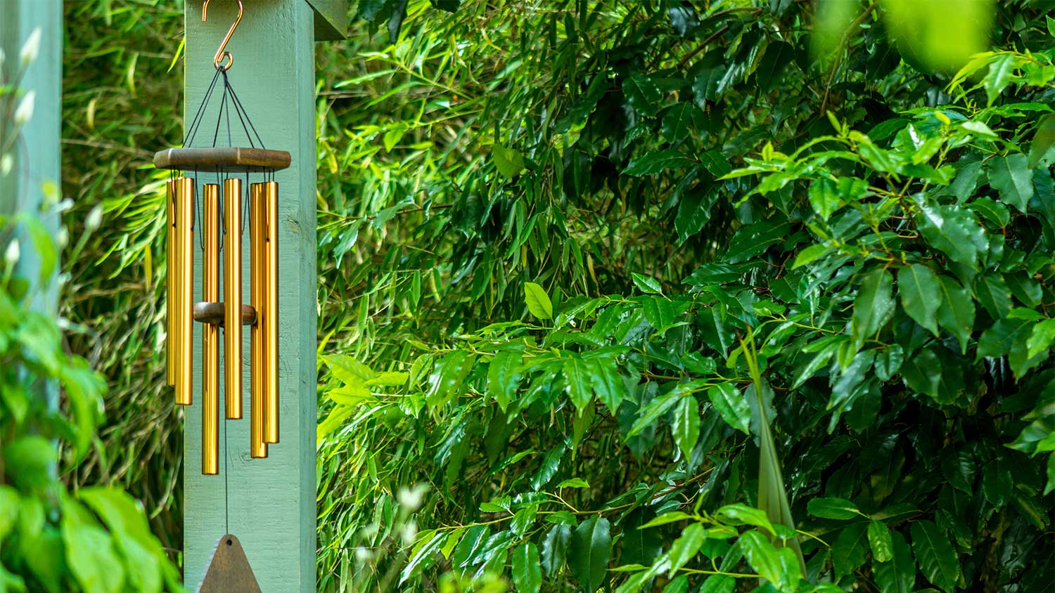 A view of wind chimes hanging on a house