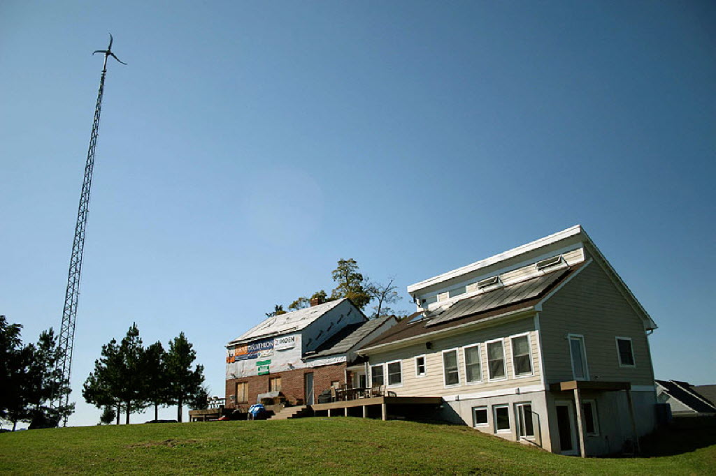 A home with solar panels and a wind turbine