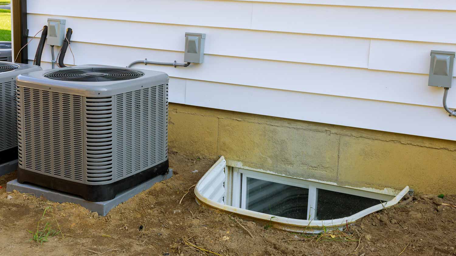  A window well next to a HVAC in a backyard