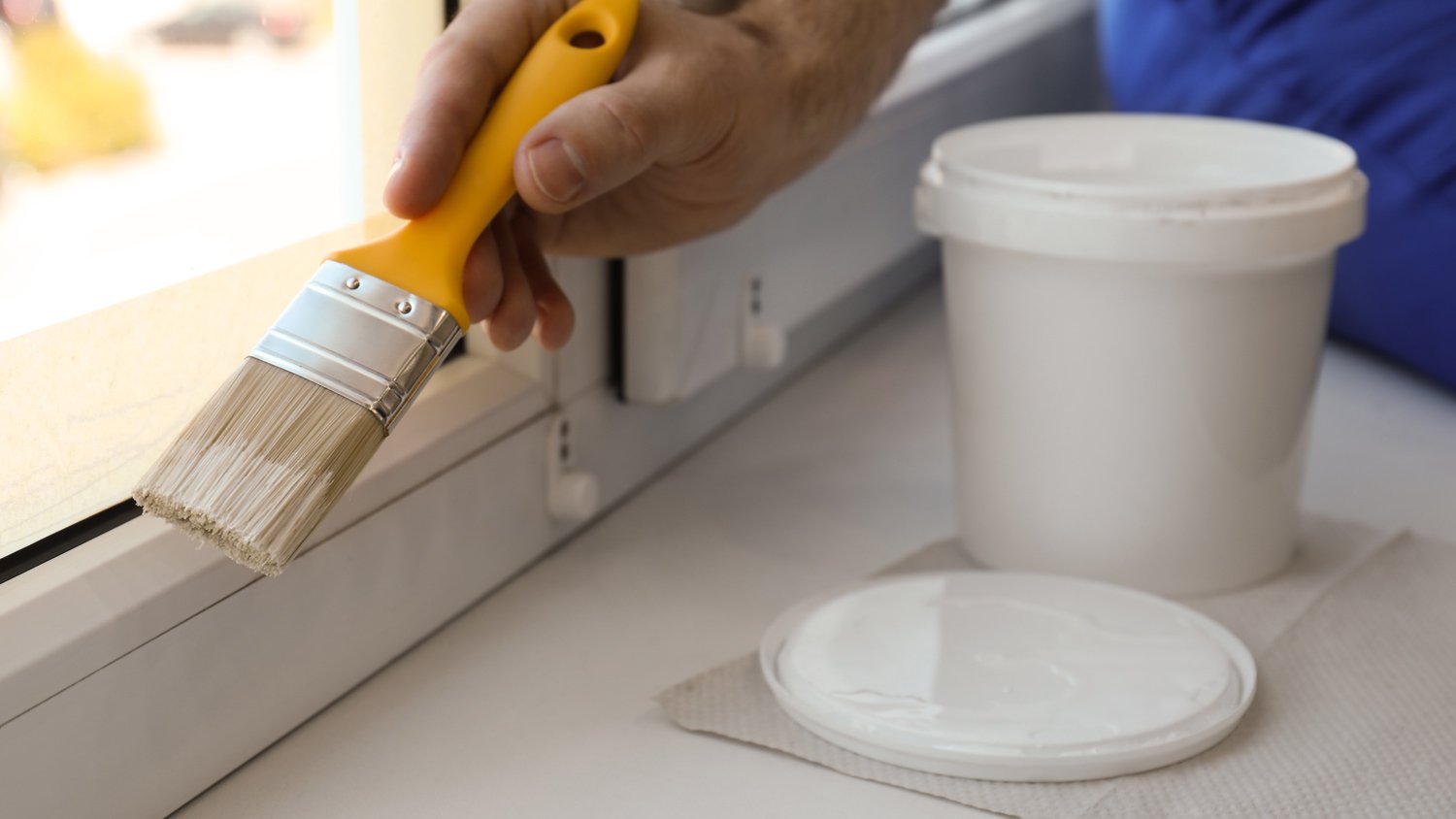 Man painting window frame at home, closeup