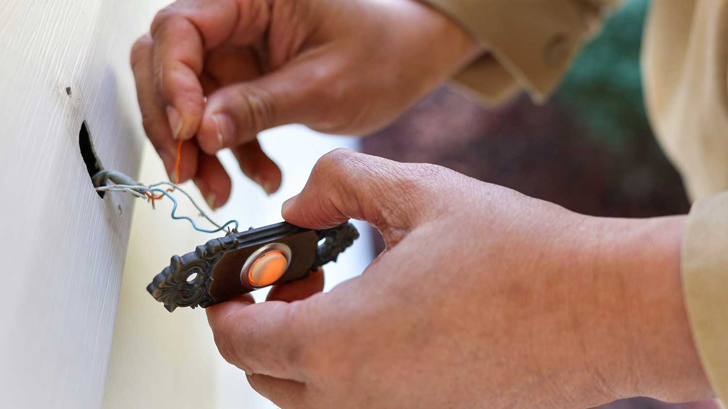 A person wiring a doorbell