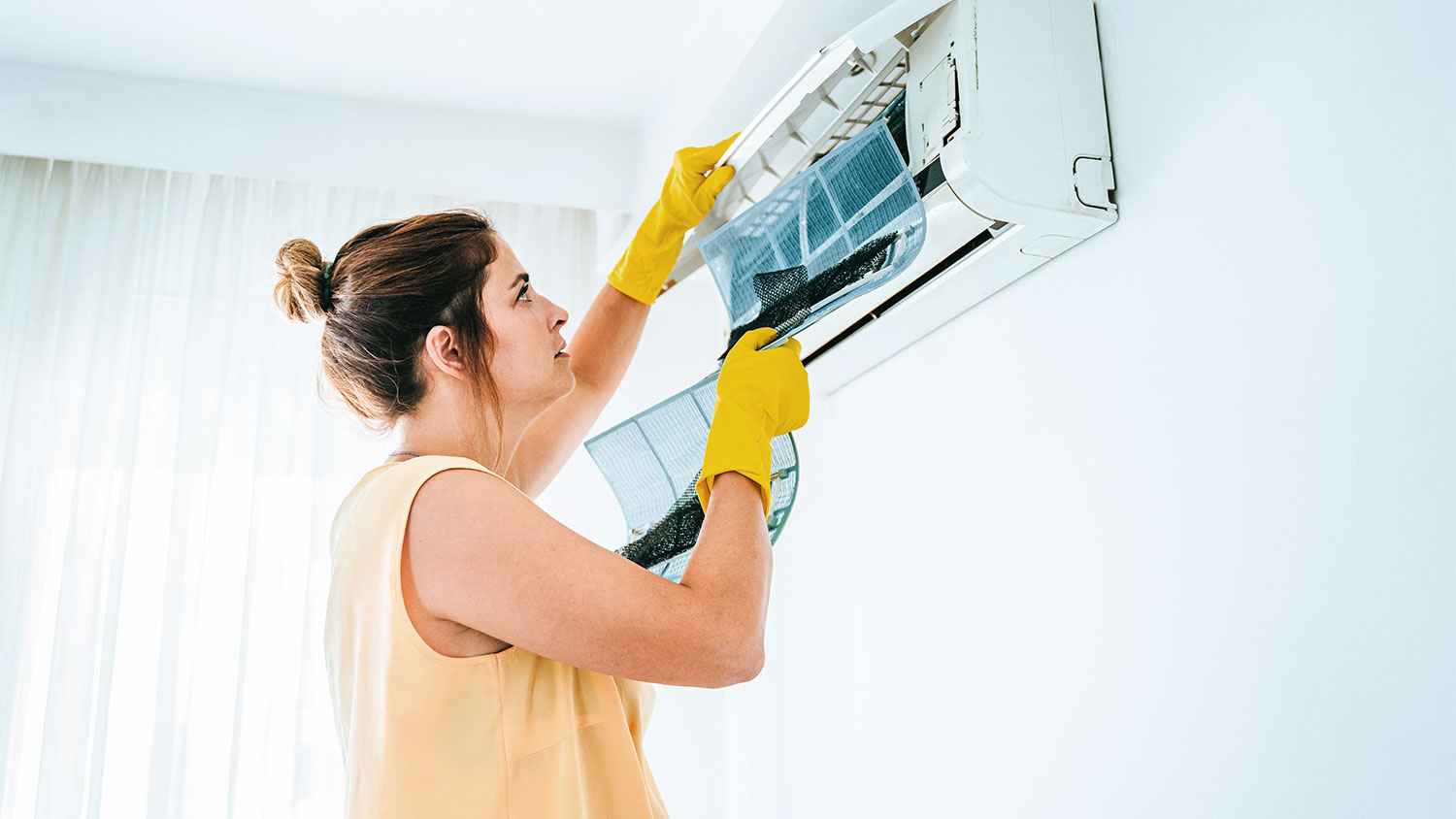 woman cleaning air conditioner filter