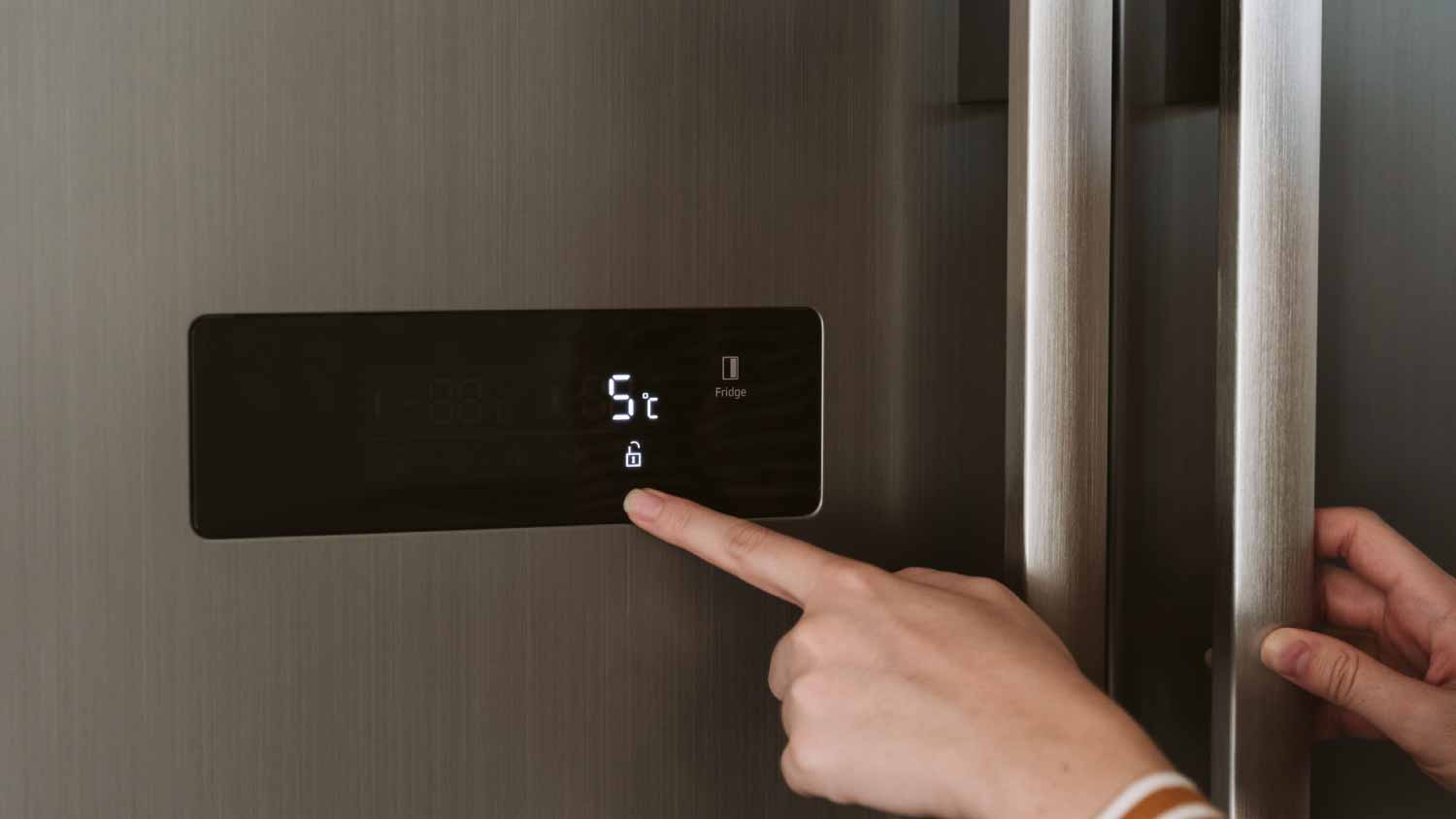 woman adjusting cooling temperature at fridge