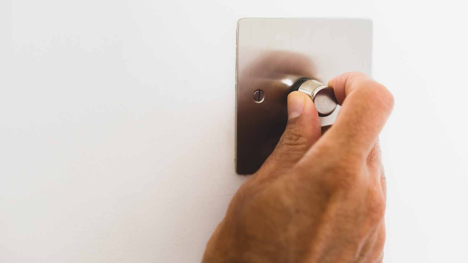 Woman adjusting a light dimmer switch