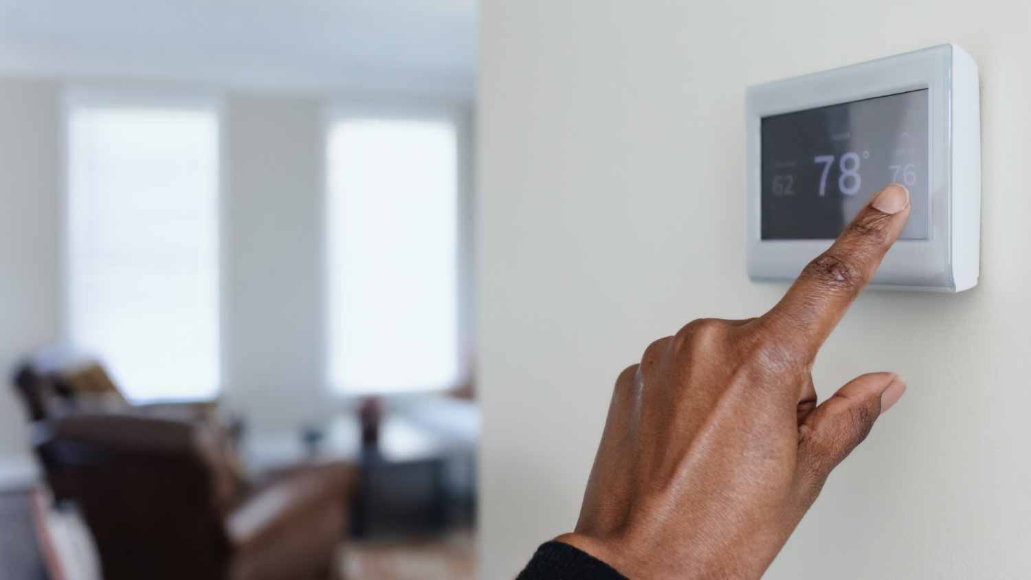 woman adjusting thermostat