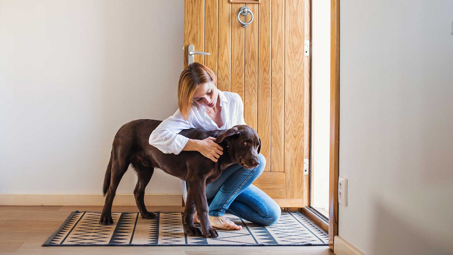 Woman and a dog sitting by the entry door