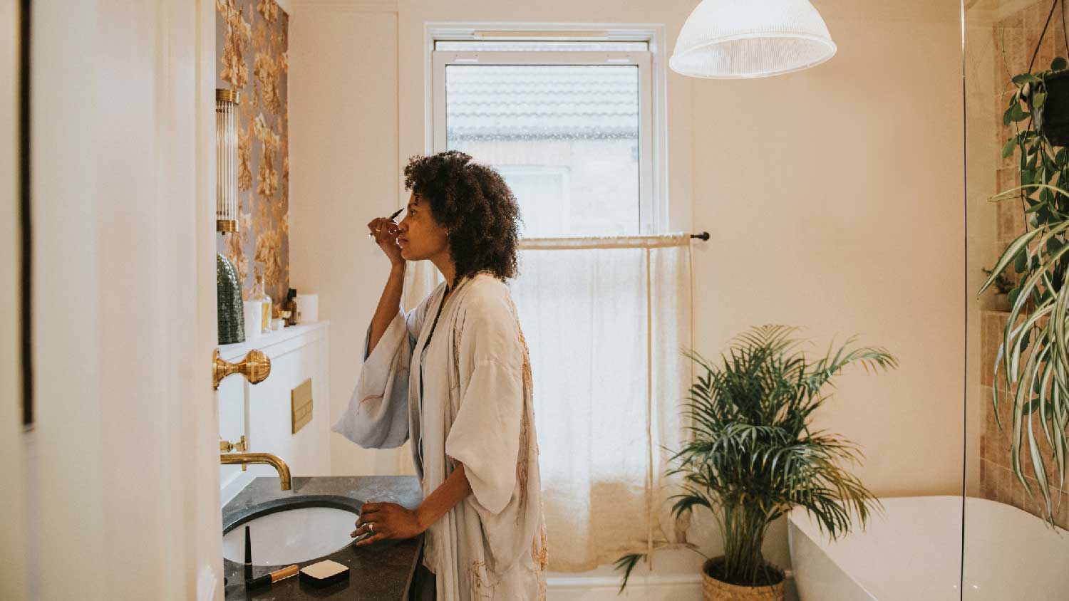 A woman applying make-up in the bathroom