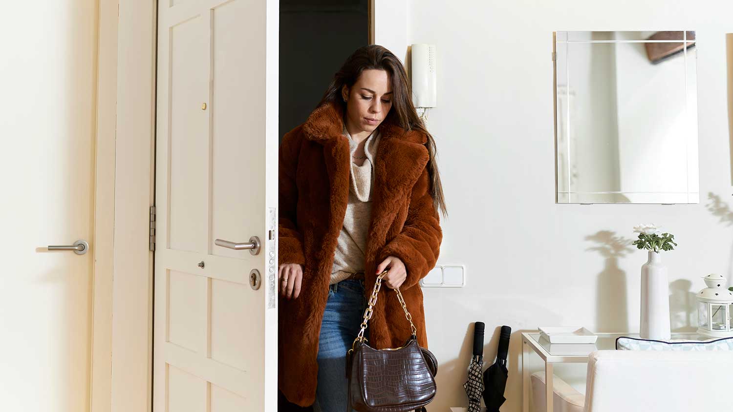 Woman opening front door to enter her home