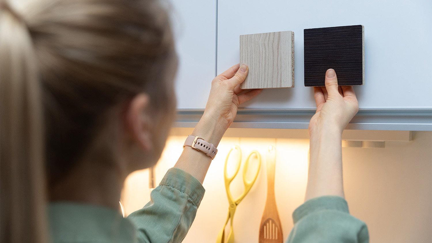 woman comparing wood cabinet samples 