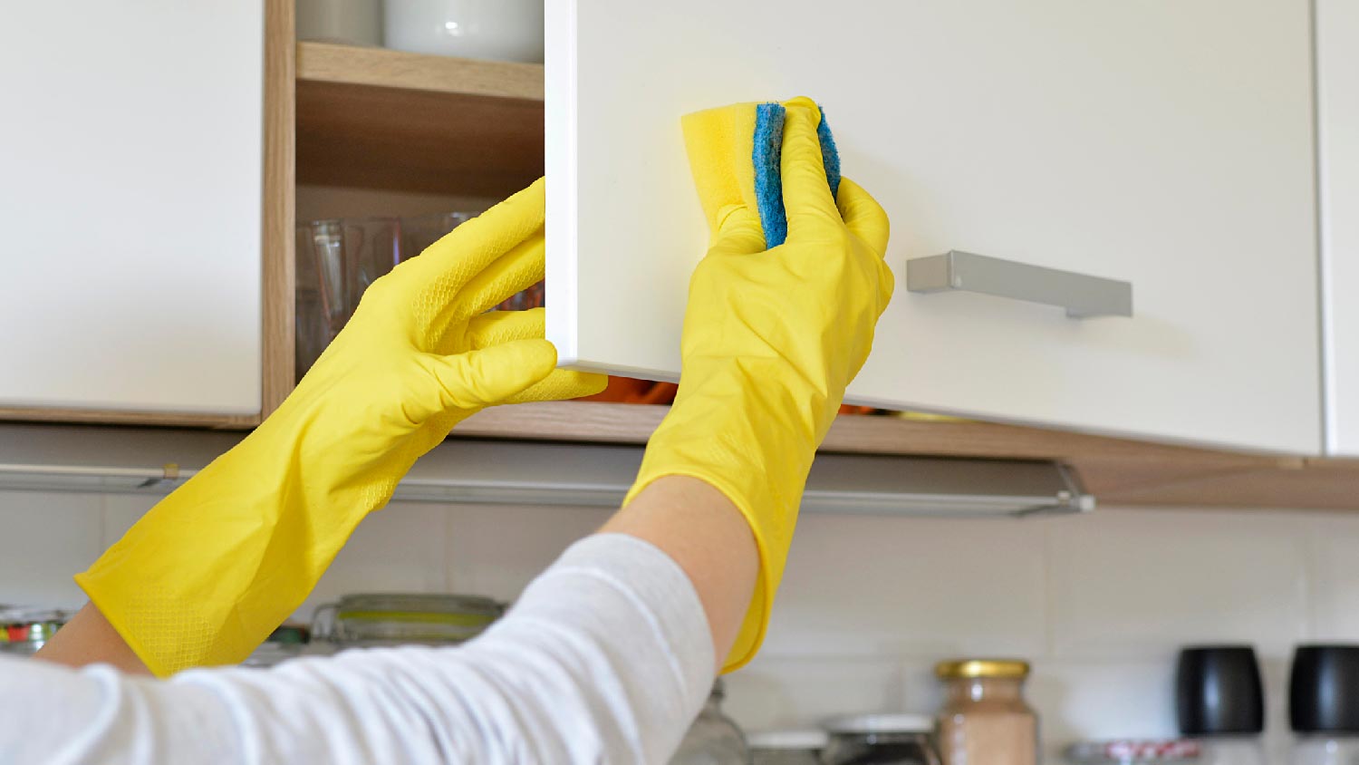 A woman cleaning a cabinet door