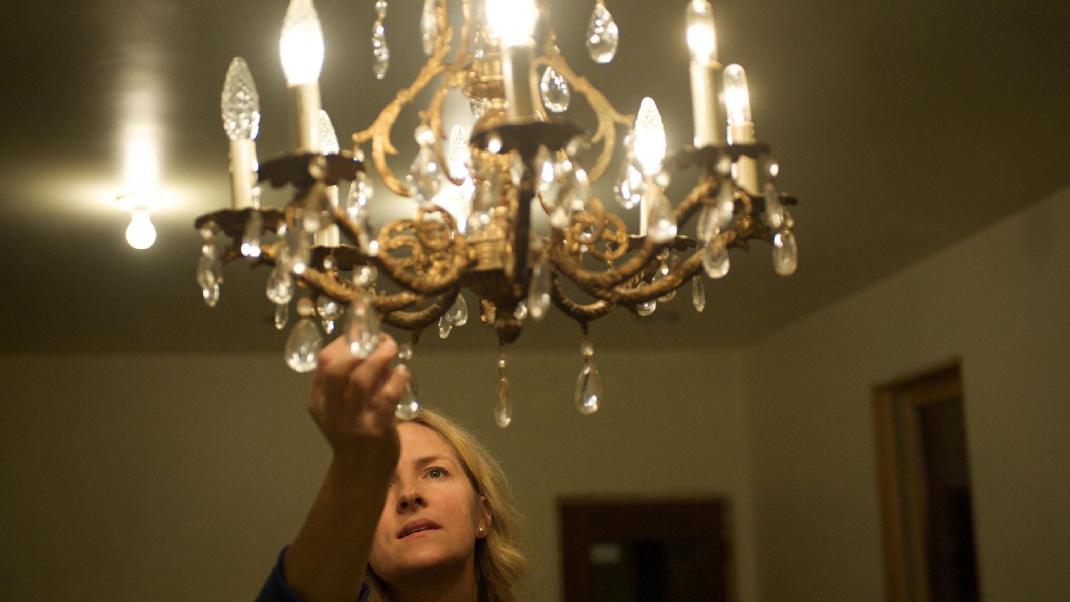 A woman cleaning a chandelier