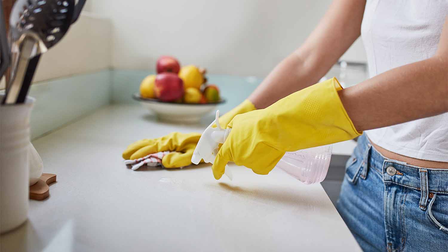 woman spraying kitchen counter 