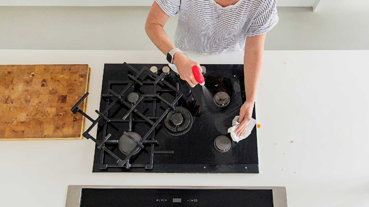 A woman cleaning a gas stove