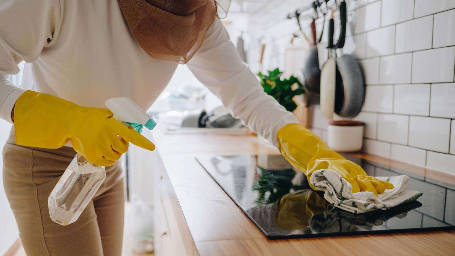 A woman cleaning a glass stove top