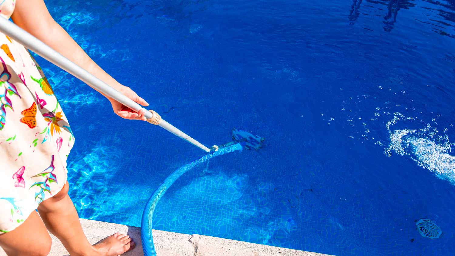 A woman cleaning a pool with a brush