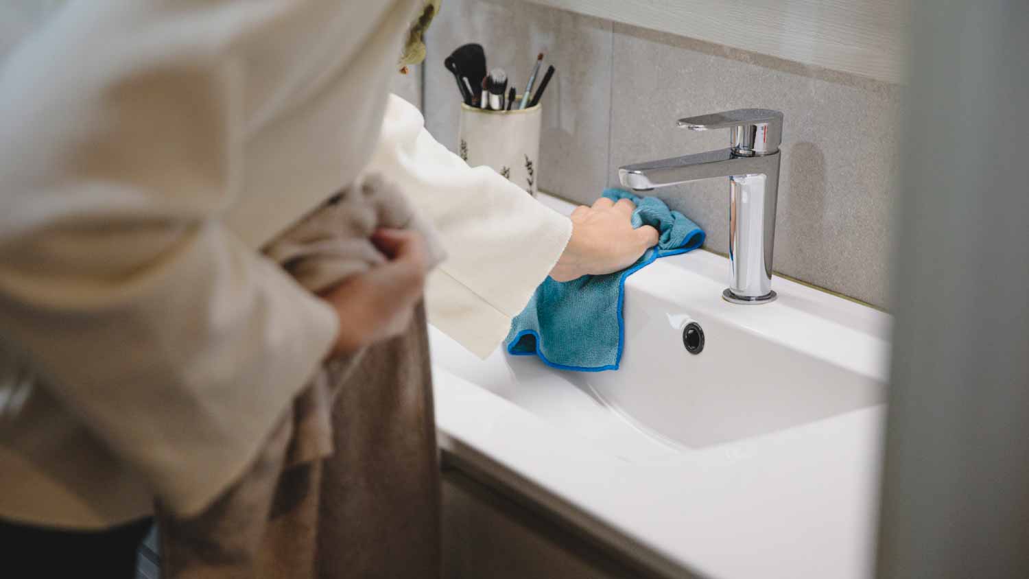 woman cleaning white sink