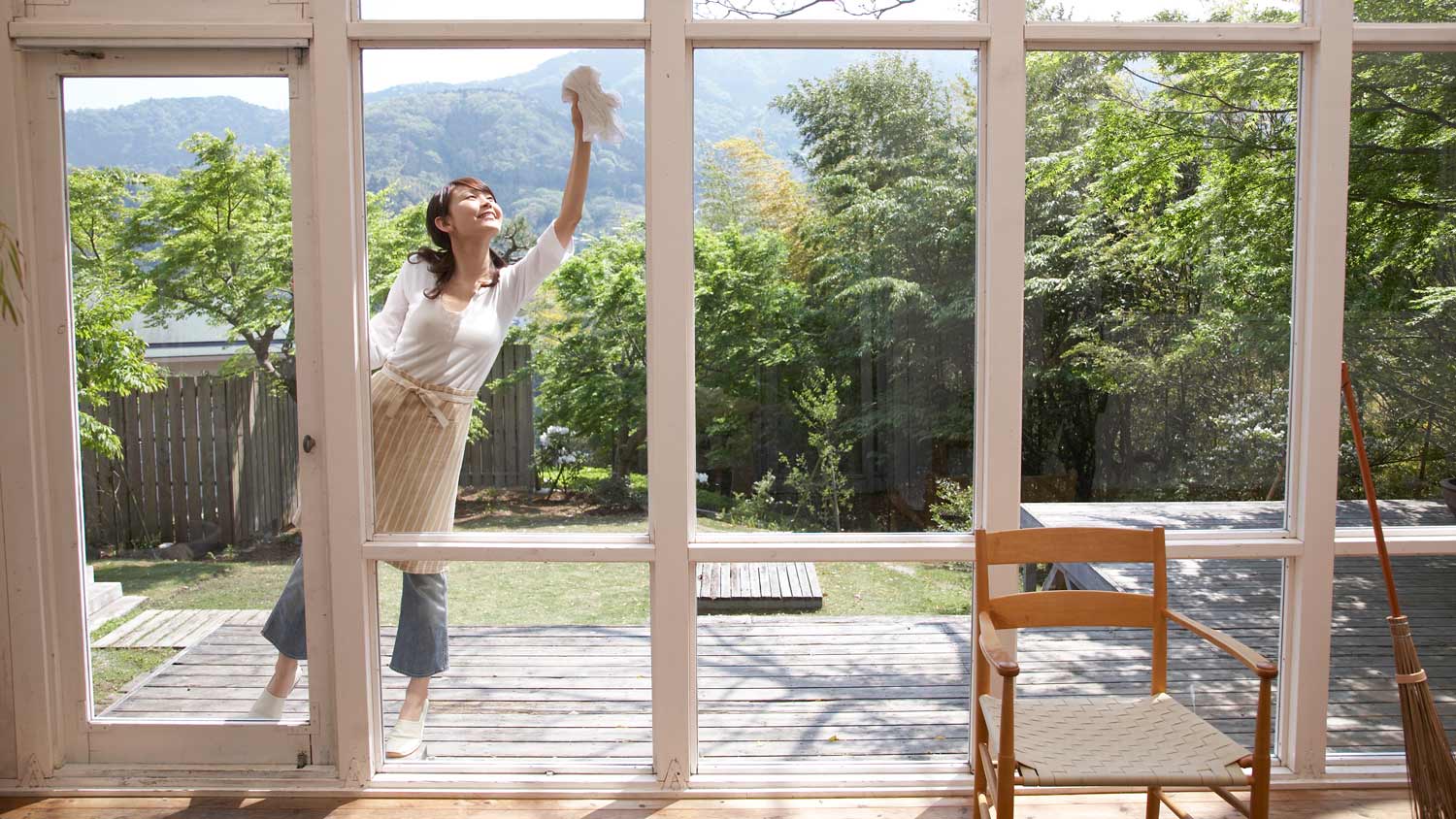 A woman on a patio cleaning the exterior side of windows