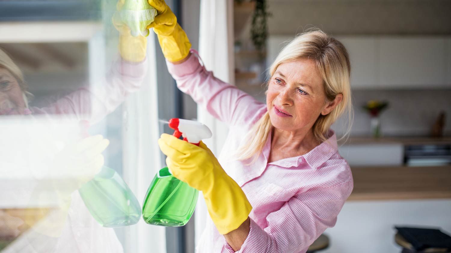 woman cleaning windows in home
