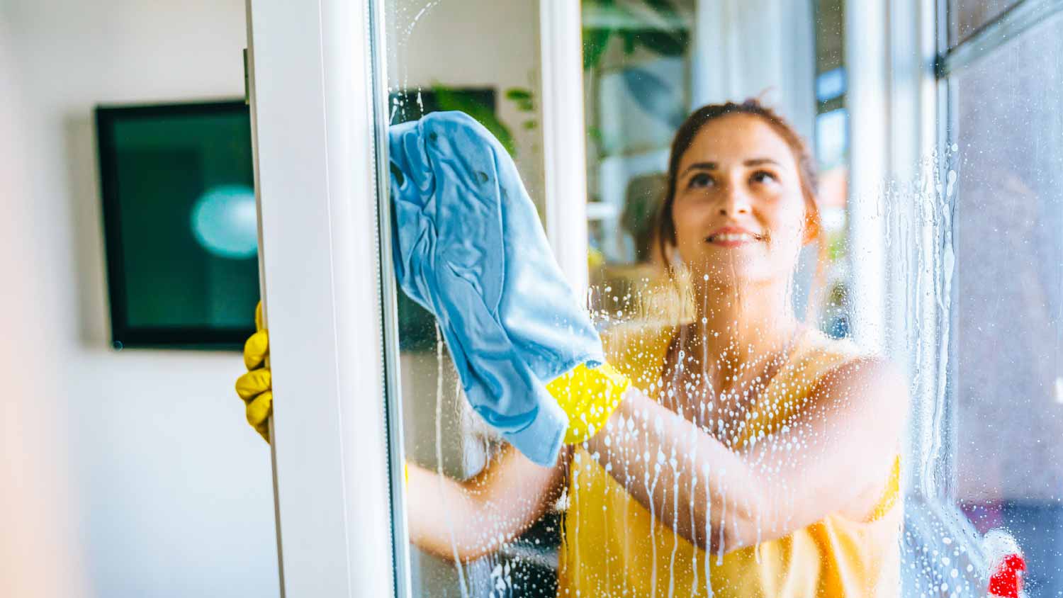 Woman cleaning and wiping window