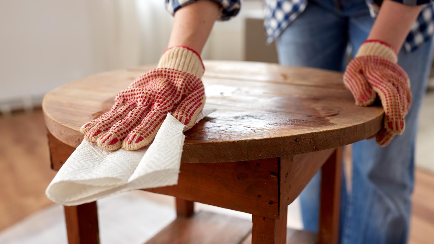 A woman cleaning a wooden table